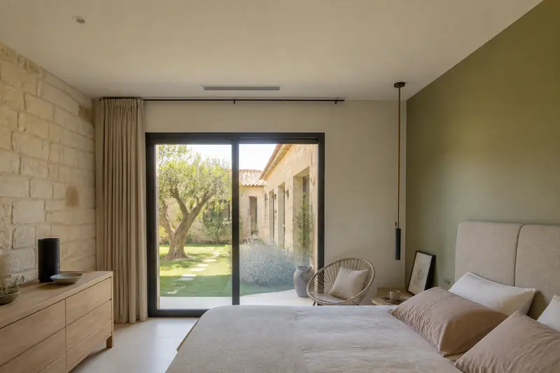 Grille de soufflage discrète au plafond d'une chambre, climatisation gainable installée dans les combles