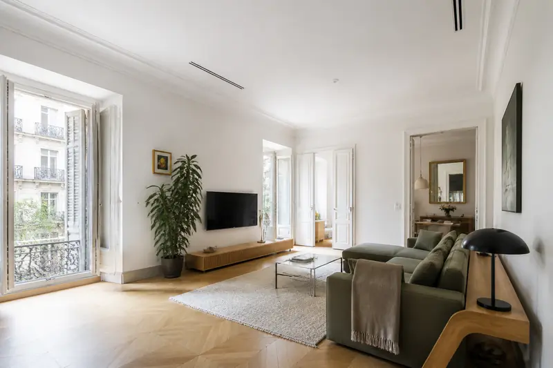 Grille encastrée dans un faux plafond blanc d'un séjour, unité gainable cachée dans le couloir